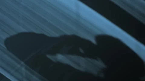 Dark moonlight shadow from office window as man talks on phone at night Stockbeeldmateriaal 331308197