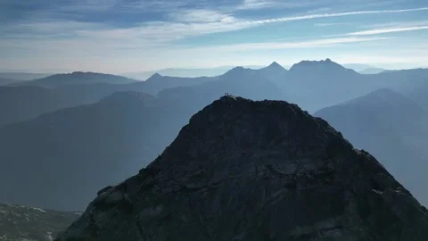 Dark mountain summit with hikers at the top, drone shot Stock Footage 289575589