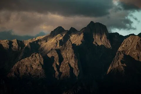 Dark mountain with sun rays hitting the peak and clouds at the top
Good for a de Stock Photos