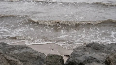 Dark murky waves breaking on shore 4k 10bit Stock Footage 93851570
