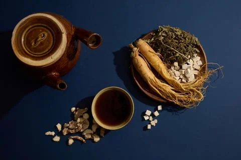 On a dark navy blue background, folk herbs are displayed on wooden plates dec Stock Photos