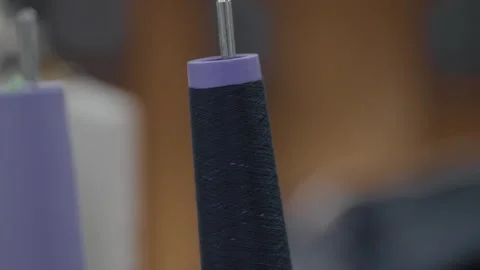 Dark Navy Thread Spool on Industrial Sewing Machine Pin in Factory Stock Footage 332948804