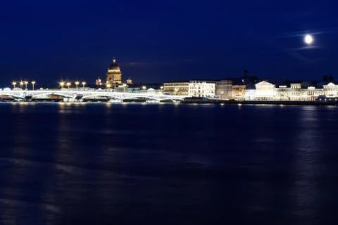 A dark night river against the backdrop of a panorama of the city brightly li Stock Photos