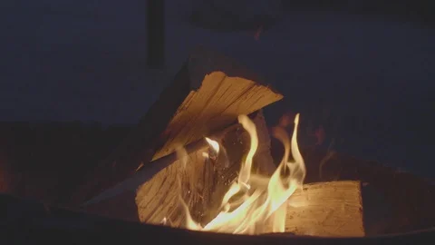 Dark night time desert campfire camping wood burns brightly in darkness. Slow Stock Footage 109479315