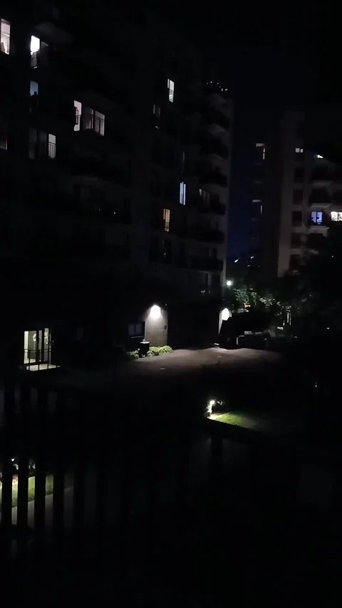 Dark night view of a residential building and courtyard with street lights Stock Footage 341757789