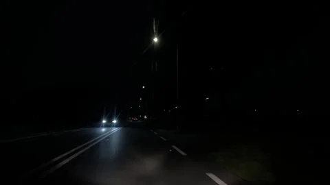 Dark nighttime road view with receding streetlights and faint traffic lights 스톡 동영상 343009044