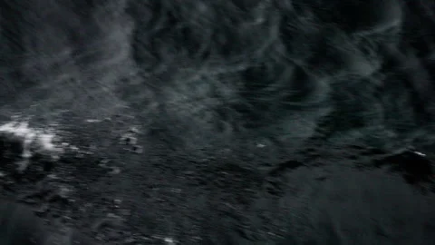 Dark ocean surface with restless ripples and subtle foam streaks under low light Stock Footage 318297089