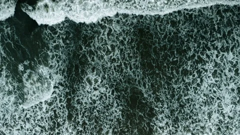 Dark ocean water with rolling waves crashing from above. Drone 4K. Stock Footage 168843753