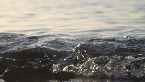 Dark ocean water splashes gently with tiny droplets under sunlight. Stock Footage 337413249