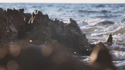 Dark ocean waves crash against jagged rocks on the coast. Stock Footage 337406878
