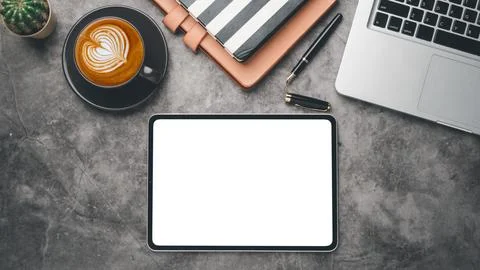 Dark office desk workplace with blank screen tablet, laptop, pen, notebook .. Stock Photos