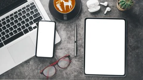 Dark office workplace with blank screen tablet and smartphone, laptop compu.. Stock Photos
