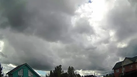Dark ominous storm clouds gathering over houses Stock Footage 341294336
