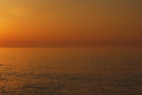 Dark orange colored sunset over the sea or ocean Stock Photos