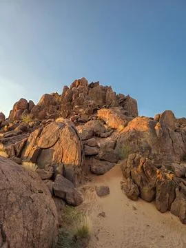 Dark orange rocks lit by the sunset sky at Namib Naukluft national park, Nami Stock Photos