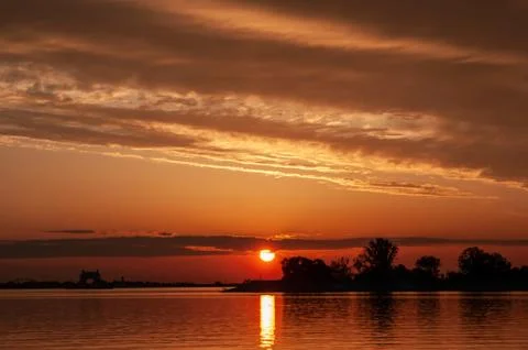 Dark orange sunset spring evening on the river or reservoir Foto stock