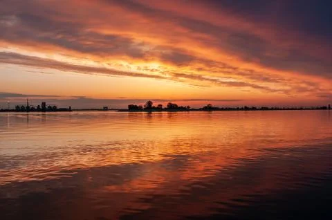 Dark orange sunset spring evening on the river or reservoir Foto stock