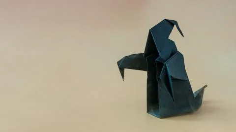 A dark paper ghost on a colored background. Stock Photos