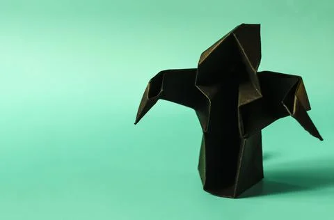 A dark paper ghost on a colored background. Stock Photos