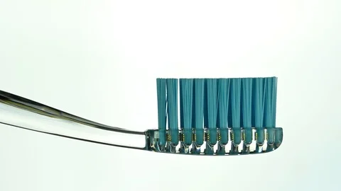 A dark paste is squeezed onto a transparent toothbrush Stock Footage 127115432