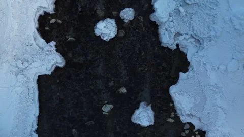 A dark patch surrounded by pristine snow, creating a unique winter landscape Stock Footage 300119631