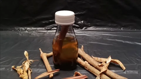 Dark Poison Potion Bottle with Tree Stem Slow Tilting Down Shot Stock Footage 344924291
