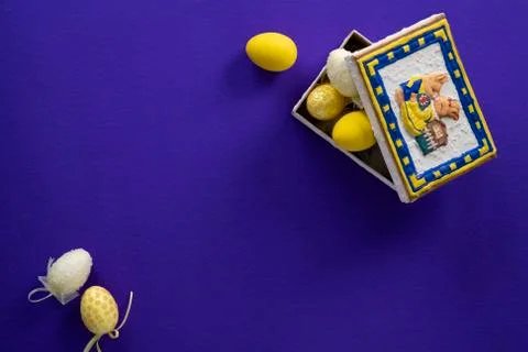 Dark purple background with an easter bunny box full of yellow eggs Stock Photos