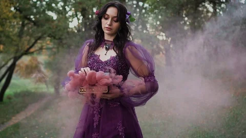 Dark queen with flowers in her dark hair curses the light and sets damned souls Stock Footage 104771207