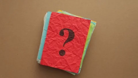 A dark question mark printed on a crumpled red piece of paper. Stock Footage 345926923