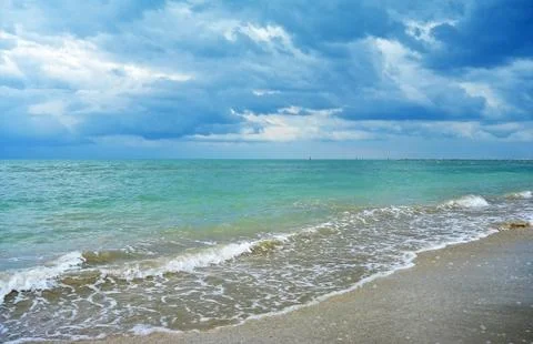 Dark Rain Clouds over turquoise Sea and sand Beach Stock Photos
