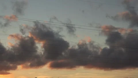 Dark rain clouds in warm evening sunset sky, summer cloudscape in time lapse Stock Footage 163185497