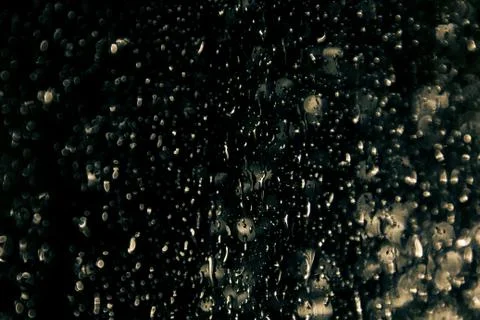 Dark rain drops on window at night Stock Photos