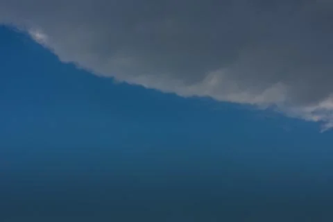 Dark raincloud from above on blue sky Stock Photos