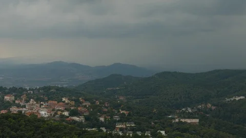 Dark rainy clouds over cozy valley village, Barcelona Stock Footage 99886737