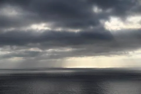 Dark rainy cloudscape at sunset with sunrays through the clouds Stock-Fotos