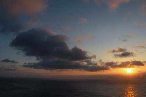 Dark rainy cloudscape at sunset with sunrays through the clouds Stock Photos