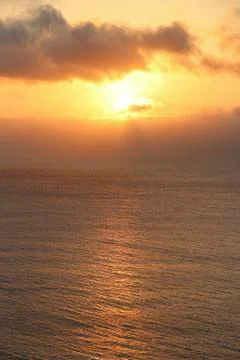 Dark rainy cloudscape at sunset with sunrays through the clouds Stock Photos