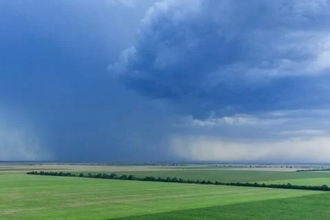 Dark rainy sky and dramatic black clouds being raining. Big rain storm and fi Stock Photos