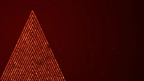 On a dark red background, an abstract glowing orange Christmas tree made of Stock Footage 284942036