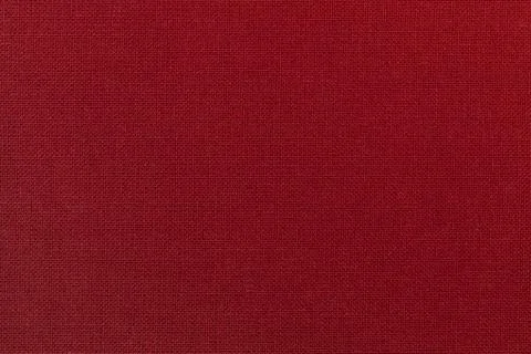 Dark red background from a textile material. Fabric with natural texture. Bac Stock Photos
