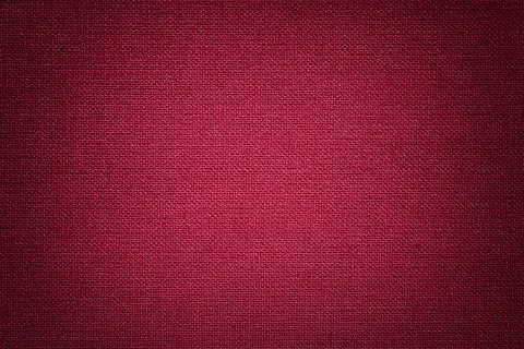Dark red background from a textile material. Fabric with natural texture. Stock Photos