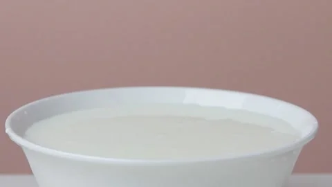 A dark red berry is falling into sour cream Vidéo 135578335