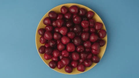 Dark red cherries on a rotating plate Stock Footage 135577499