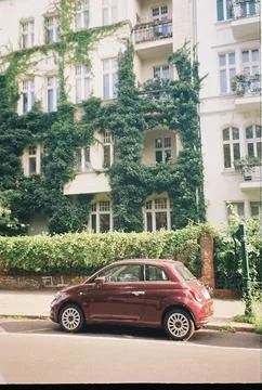 Dark Red Compact Car Parked by an Ivy-Clad Berlin Apartment Building Stock Photos