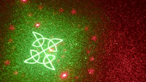 On a dark red fine-grained gradient background, moving multi-colored figures Stock Footage 240523134