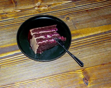 Dark Red Layer Cake Slice with Cream on a Black Plate Stock Photos