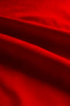 Dark red matte background of suede fabric, closeup. Velvet texture of seamles Stockfoto's