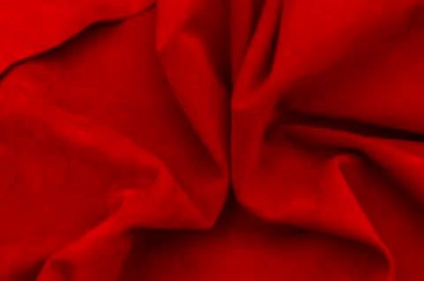 Dark red matte background of suede fabric, closeup. Velvet texture of seamles Stockfoto's