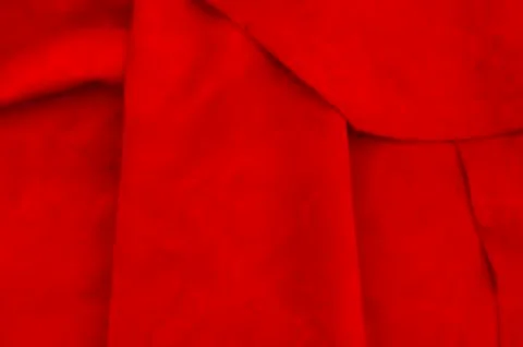 Dark red matte background of suede fabric, closeup. Velvet texture of seamles Stockfoto's
