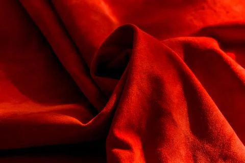 Dark red matte background of suede fabric, closeup. Velvet texture of seamles Stockfoto's